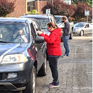 Salt of the Earth volunteer handing donated food directly to a community member at a Snohomish County distribution
