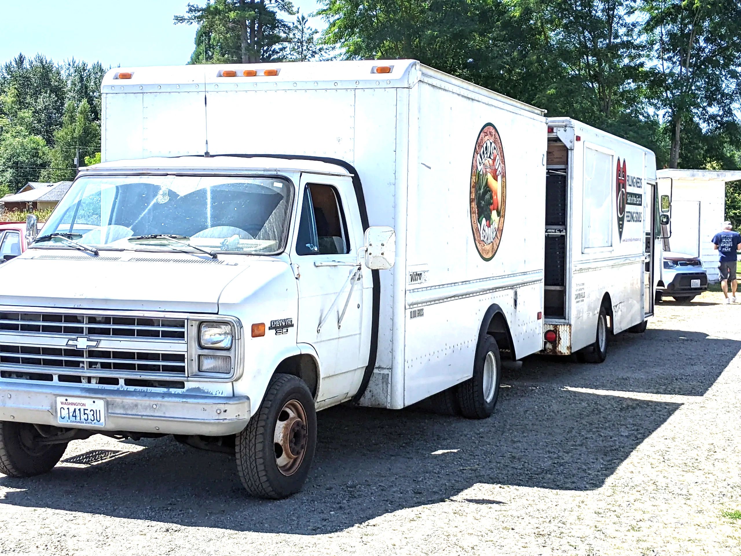 Salt of the Earth Food Blessing delivery truck and trailer marked Food for All at a distribution site in Snohomish County