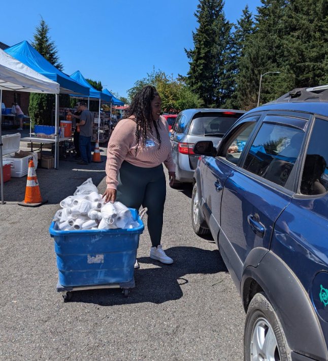 Volunteer bringing food to a vehicle at the Arlington distribution
